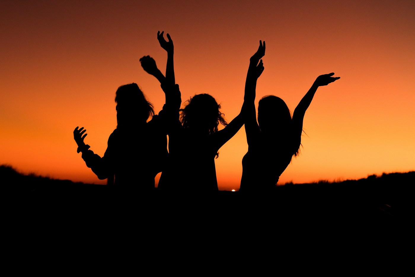 Silhouettes of three young people dancing - Best camping activities for teens
