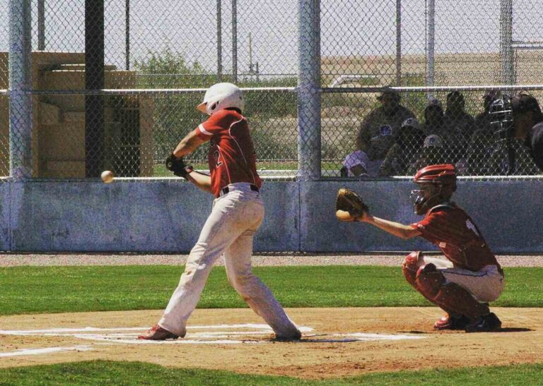 Two boys playing baseball in game, one catching and one batting - The 5 Best Youth Batting Gloves