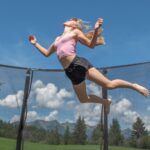 Girl jumping on trampoline with enclosure netting - How to Keep a Trampoline from Blowing Away: 7 Basic Steps